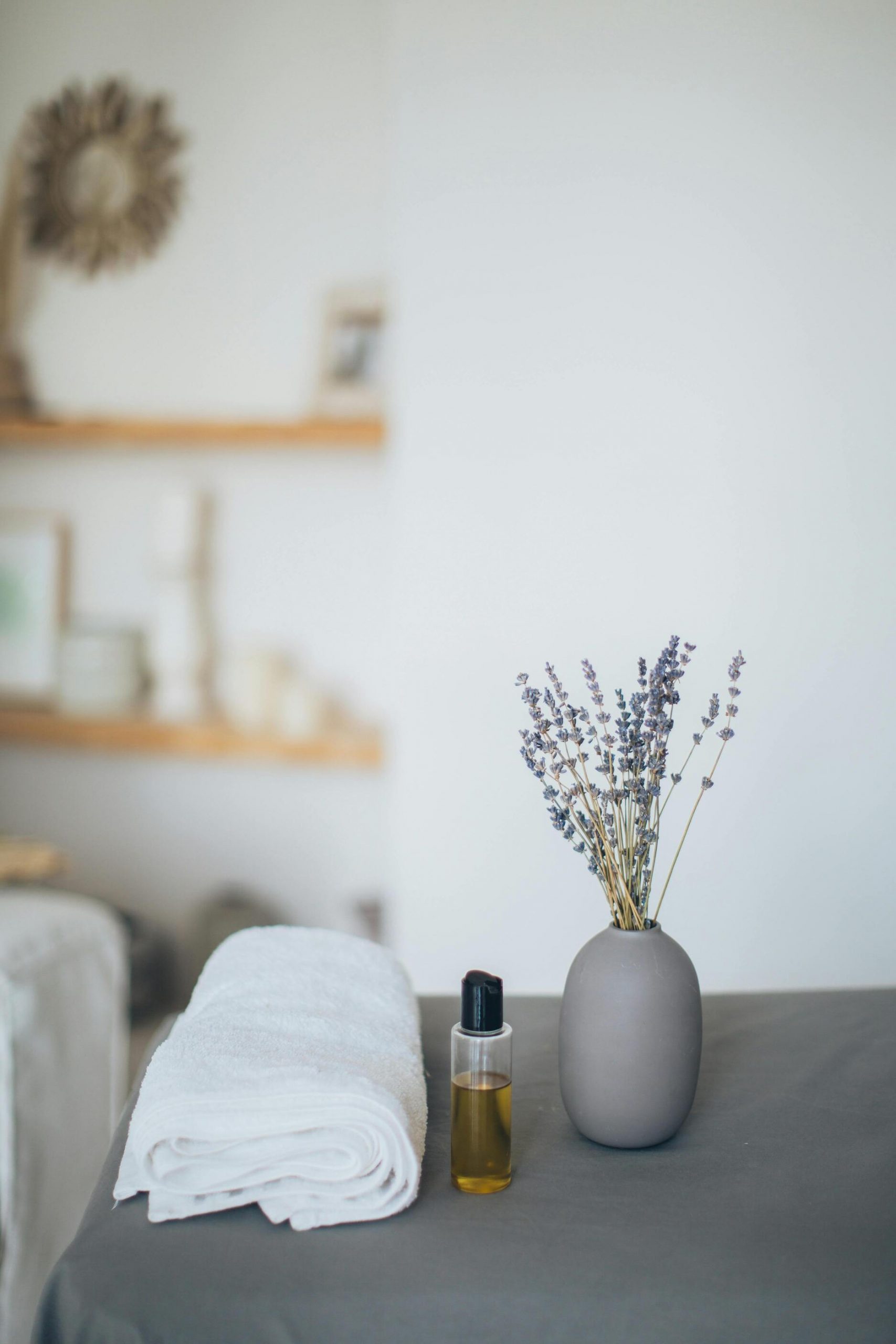 table de massage avec huile et plantes séchées à Lorient